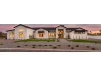 Striking exterior of a white home with stone accents, manicured landscaping, and a paver driveway leading to the entrance at 6147 E Desert Cove Ave, Scottsdale, AZ 85254