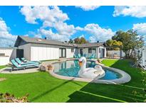 Inviting backyard featuring a pool, lounge chairs, and lush green lawn, perfect for outdoor relaxation at 8213 E Fairmount Ave, Scottsdale, AZ 85251