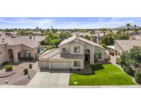 A beautiful two-story home featuring a well-manicured lawn, a three car garage and a clay tile roof at 9057 E Pine Valley Rd, Scottsdale, AZ 85260