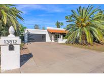 Charming home with a well manicured lawn, mature palm trees, and a terracotta roof at 13812 N 51St St, Scottsdale, AZ 85254