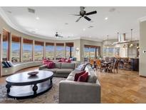 Open living room with large windows providing mountain views and an open floor plan to the dining and kitchen areas at 15106 E Miravista --, Fountain Hills, AZ 85268