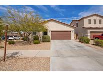 Charming single-story home with a two-car garage, desert landscaping, and a well-maintained front yard at 16658 W Mescal St, Surprise, AZ 85388