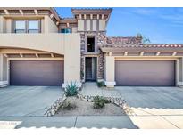 Inviting two-story home featuring desert landscaping and a stone accent entrance to the private courtyard at 19700 N 76Th St # 2148, Scottsdale, AZ 85255