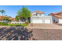 Inviting home showcasing lush landscaping, a mature shade tree, and a convenient three-car garage at 2218 E Mallard Ct, Gilbert, AZ 85234