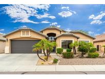 Charming home with a well-maintained front yard, desert landscaping, and a two-car garage at 2318 W Hedgehog Pl, Phoenix, AZ 85085