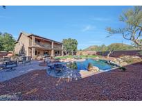 Expansive backyard featuring a pool, outdoor seating, lawn, mature trees, and a two-story house at 25767 N 67Th Dr, Peoria, AZ 85383