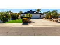 Charming single-Gathering home with a well-manicured lawn, palm trees, and a basketball hoop above the garage at 2717 E Aster Dr, Phoenix, AZ 85032