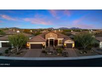Stunning desert home featuring lush landscaping, a stone facade, and a tile roof, set against a mountain backdrop at 30311 N 52Nd Pl, Cave Creek, AZ 85331