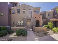 Inviting townhome featuring colorful stucco, gated front patio, and desert landscaping at 3935 E Rough Rider Rd # 1264, Phoenix, AZ 85050