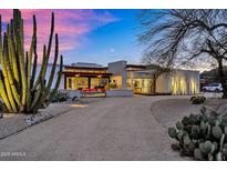 Stunning modern home with desert landscaping, cacti and a gravel driveway at twilight at 5033 E Turquoise Ave, Paradise Valley, AZ 85253