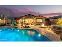 Inviting backyard oasis featuring a sparkling pool, spa, fire pit, and covered patio perfect for outdoor entertaining at 560 W Powell Way, Chandler, AZ 85248