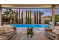 Inviting backyard features a sparkling pool, stylish patio furniture, lush landscaping, and a beautiful sunset view at 8738 E Rose Ln, Scottsdale, AZ 85250