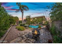 Relaxing backyard with a pool, spa, fire pit, mature landscaping, and a charming paver patio at 9364 S Margo Dr, Tempe, AZ 85284