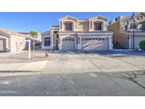 Two-story home featuring a beige stucco exterior, a three-car garage and a well-maintained front yard at 12905 W Crocus Dr, El Mirage, AZ 85335