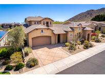 Stunning home featuring a tile roof, desert landscaping, and a spacious driveway leading to a two-car garage at 26015 N 85Th Dr, Peoria, AZ 85383