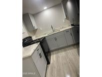 Well-lit kitchen with gray cabinets, granite countertops, black appliances, and modern fixtures at 2662 N 43Rd Ave # B, Phoenix, AZ 85009