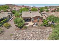 A beautiful backyard featuring a covered patio, outdoor dining area, lounge chairs, and desert landscaping at 28351 N 130Th Dr, Peoria, AZ 85383