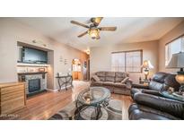 Cozy living room with a fireplace, ceiling fan, and plentiful seating space at 359 Felspar Dr, Apache Junction, AZ 85119