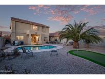 A backyard featuring a private pool, putting green, and well-maintained landscaping at 36469 W Alhambra St, Maricopa, AZ 85138
