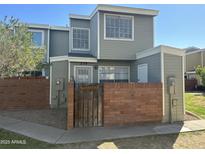 Two-story townhouse with brick fence and well-maintained front yard under a clear blue sky at 510 N Alma School Rd # 259, Mesa, AZ 85201
