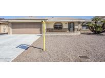 Charming home with a two-car garage, decorative brick accents, and desert landscaping at 8320 E Nido Ave, Mesa, AZ 85209