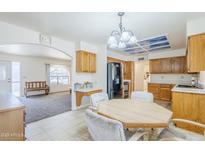 Eat-in kitchen featuring oak cabinets, black appliances, and tiled flooring at 8320 E Nido Ave, Mesa, AZ 85209