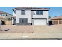 Two-story home featuring a two-car garage, low maintenance landscaping, and black and white trim at 9230 N 82Nd Ln, Peoria, AZ 85345