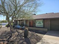 Charming single-story home featuring desert landscaping and a warm, inviting entrance with wood door at 2833 E Emile Zola Ave, Phoenix, AZ 85032