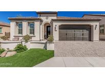 Charming home featuring a brown garage door, landscaped front yard, and inviting entryway with decorative details at 36053 N Stoneware Dr, Queen Creek, AZ 85140