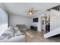 Bright living room features a ceiling fan, sleek floors, and stairway access to the second floor at 6351 N 49Th Ave, Glendale, AZ 85301