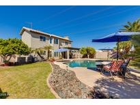 Inviting backyard featuring a sparkling pool, patio area, and lush landscaping under a blue sky at 7053 S Heather Dr, Tempe, AZ 85283