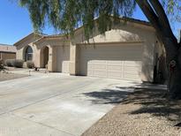 Lovely single-story home boasting a three-car garage and desert landscaping on a sunny day at 10980 E Winchcomb Dr, Scottsdale, AZ 85255
