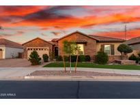 Charming single-story brick home featuring a well-manicured lawn and beautiful desert landscaping at 21647 S 223Rd Pl, Queen Creek, AZ 85142