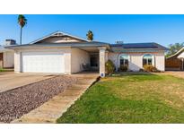 Charming single-story home featuring a well-manicured lawn, desert landscaping, and solar panels at 2962 E Dolphin Ave, Mesa, AZ 85204