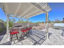Outdoor kitchen with a built-in grill, bar seating, and shade from a covered patio at 29674 N 127Th Ln, Peoria, AZ 85383