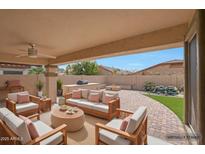 Inviting outdoor living space with plush seating, fireplace, built-in grill, and waterfall feature at 3005 W Donatello Dr, Phoenix, AZ 85086