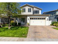 Two-story home with manicured lawn, brick driveway, and attached two-car garage on a sunny day at 3028 E Austin Dr, Gilbert, AZ 85296