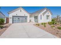 A stunning home featuring a gray glass garage door and manicured front yard landscaping at 35658 N Lodestone Dr, San Tan Valley, AZ 85144
