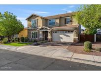 Two-story home showcasing a manicured lawn, complemented by a two car garage and charming stone accents at 4412 E Grand Canyon Dr, Chandler, AZ 85249