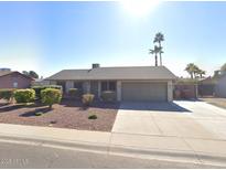 Charming single-story home with a well-maintained lawn, desert landscaping, and a two-car garage at 9003 W Griswold Rd, Peoria, AZ 85345