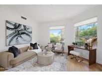Inviting living room provides ample natural light through large windows, creating a warm and relaxing atmosphere at 10290 N 117Th Pl, Scottsdale, AZ 85259