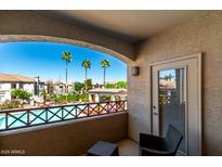 Relaxing balcony view of a community pool and palm trees, with comfortable seating at 1941 S Pierpont Dr # 2141, Mesa, AZ 85206