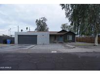 Charming single-story home featuring modern stucco siding, a gray garage door, and a manicured rock garden at 2215 W Highland Ave, Phoenix, AZ 85015