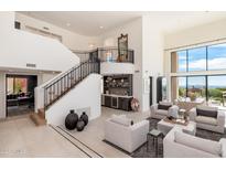 Bright living room with soaring ceilings, a staircase, and a convenient wet bar at 24350 N Whispering Ridge Way # 22, Scottsdale, AZ 85255