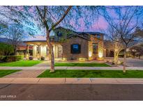 Stunning two-story home with stone accents, manicured lawn, and inviting curb appeal at dusk at 2950 E Los Altos Ct, Gilbert, AZ 85297