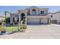 Elegant two-story home with a well-manicured lawn, desert landscaping, and a three-car garage at 9535 E Los Lagos Vista Ave, Mesa, AZ 85209