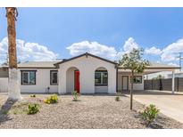 Charming single-story home featuring a red front door, arched entryway, and a low-maintenance desert landscape at 13202 N 40Th Pl, Phoenix, AZ 85032
