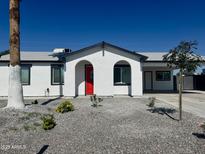 Charming single-story home with a bright red front door, arched entryway, and xeriscaped yard at 13202 N 40Th Pl, Phoenix, AZ 85032