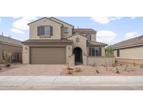 Inviting two-story home showcases a brick-paved driveway, a tiled roof, and a charming gated front entryway at 17614 W Palo Verde Dr, Litchfield Park, AZ 85340