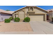 Charming single-story home with a beige exterior, well-manicured landscaping, and a two-car garage at 1946 E Kings Ave, Phoenix, AZ 85022